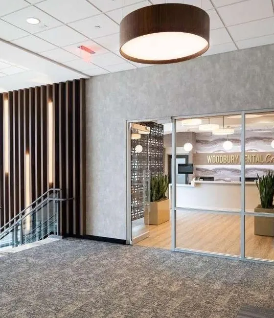 The glass entrance doors to Woodbury Dental Care, seen from the landing at the top of the stairs.