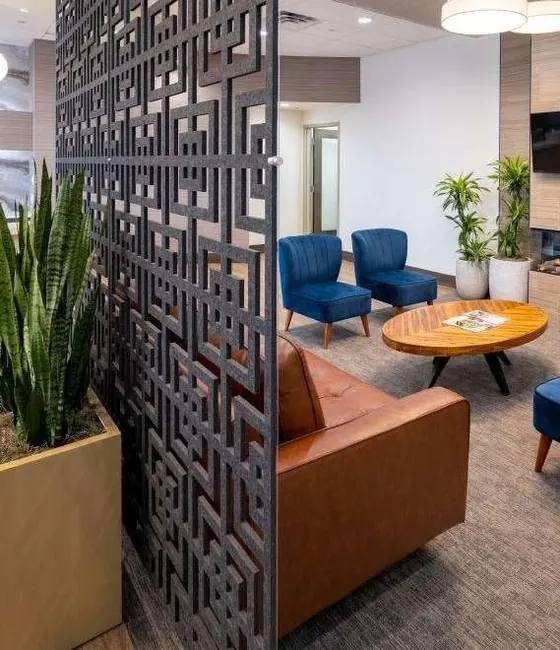 Leather sofa and blue armchairs in the lounge, behind a patterned screen.