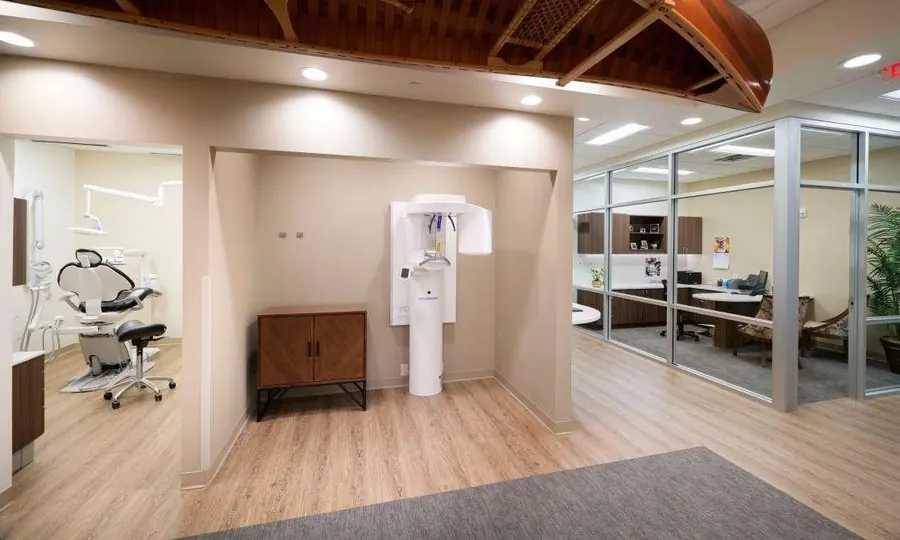 The imaging alcove at Woodbury Dental Care: a standing x-ray and 3-D imaging unit, with a treatment room to the left and a glass-walled office to the right.